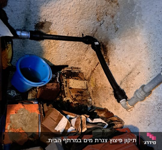 צינור שחור מחובר לקיר עם דליפה